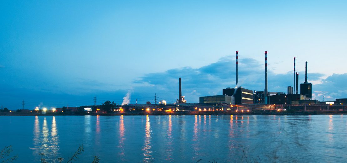 Mehrere Industrieanlagen im Abendlicht: Die Produktion ist eingefahren, die Luftschmutzung