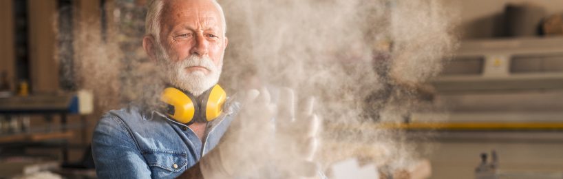 Handwerker entfernt Holzstaub: Eine wichtige Maßnahme, um Staubexplosionen vorzubeugen.