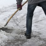Mann räumt Eis und Schnee