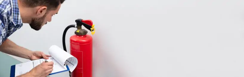 Das sind Ihre Aufgaben als Brandschutzbeauftragter Brandschutzbeauftragter überprüft einen Feuerlöscher - eine seiner Aufgaben