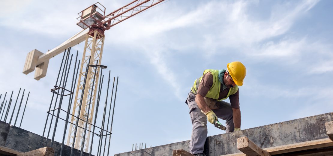 Mann arbeitet auf einer Baustelle in der Höhe: ein Arbeitsplatz mit Absturzgefahr