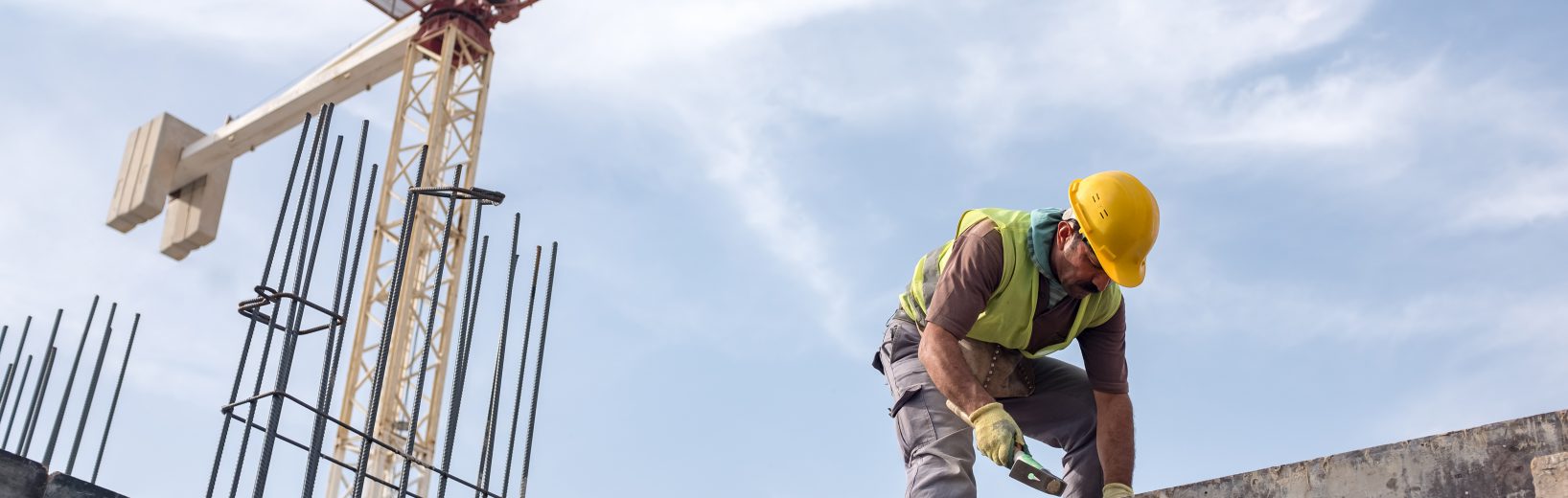 Arbeiten mit Absturzgefahr Mann arbeitet auf einer Baustelle und beachtet die Anforderunen im Arbeitsschutz auf Baustellen