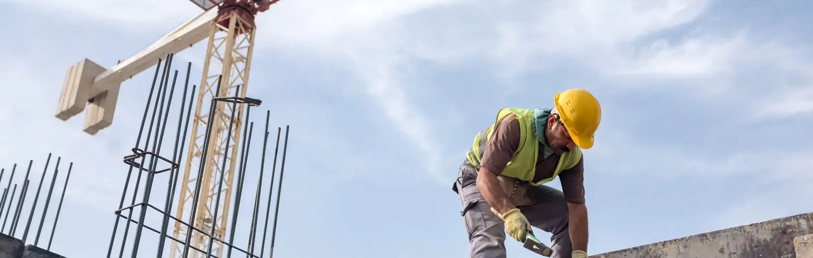 Arbeitsschutz auf Baustellen: Das müssen Sie beachten Mann arbeitet auf einer Baustelle in der Höhe: ein Arbeitsplatz mit Absturzgefahr