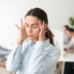 Psychische Belastung bei einer Frau durch den Lärm im Büro
