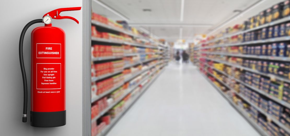Feuerlöscher vor dem Korridor eines Supermarkts für wirksamen Brandschutz im Einzelhandel