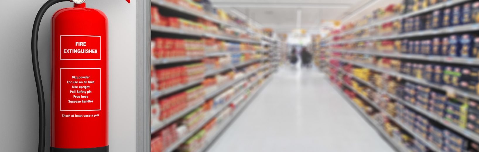 Feuerlöscher vor dem Korridor eines Supermarkts für wirksamen Brandschutz im Einzelhandel