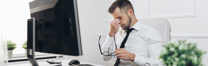 Sicherheit im Büro: Darauf kommt es an Mann reibst sich seine Augen, die vom Blick auf den Bildschirm müde geworden sind