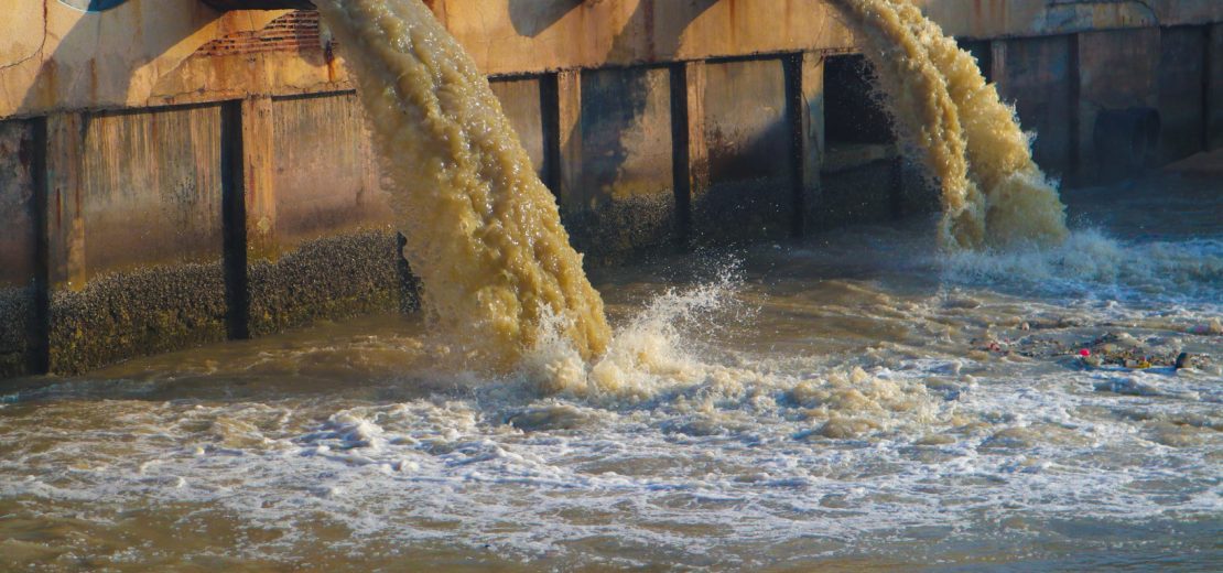Wasser aus Fabrik fliesst in einen Fluss