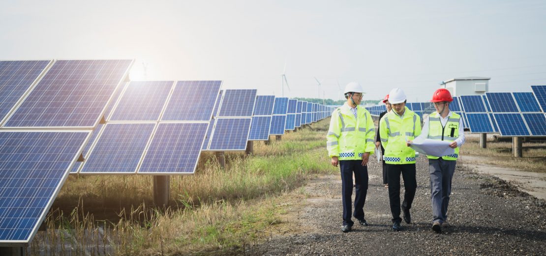 Mitarbeiter vor Solarstrom-Anlagen