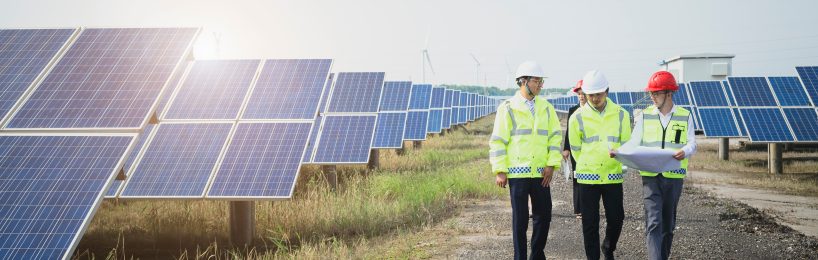 Mitarbeiter vor Solarstrom-Anlagen