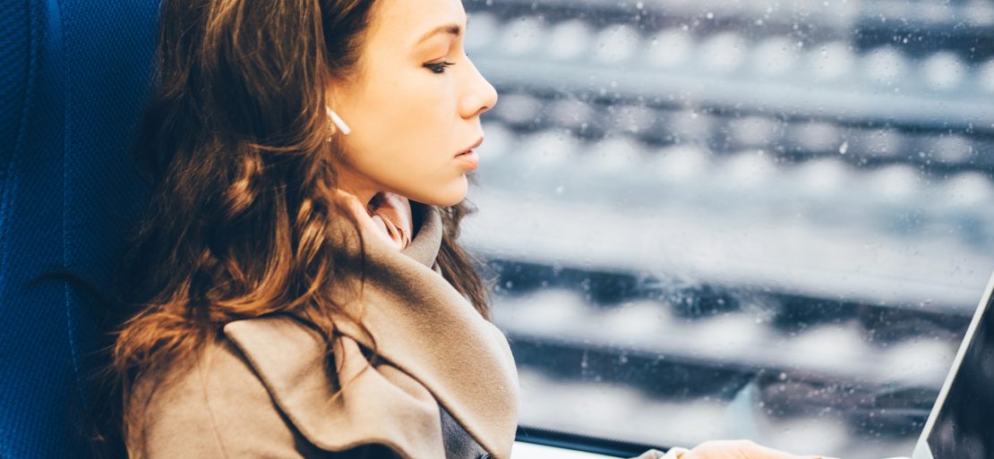 Frau arbeitet mobil im Zug: Ihr Arbeitsschutz muss eine Gefährdungsbeurteilung mobiles Arbeiten erstellen.