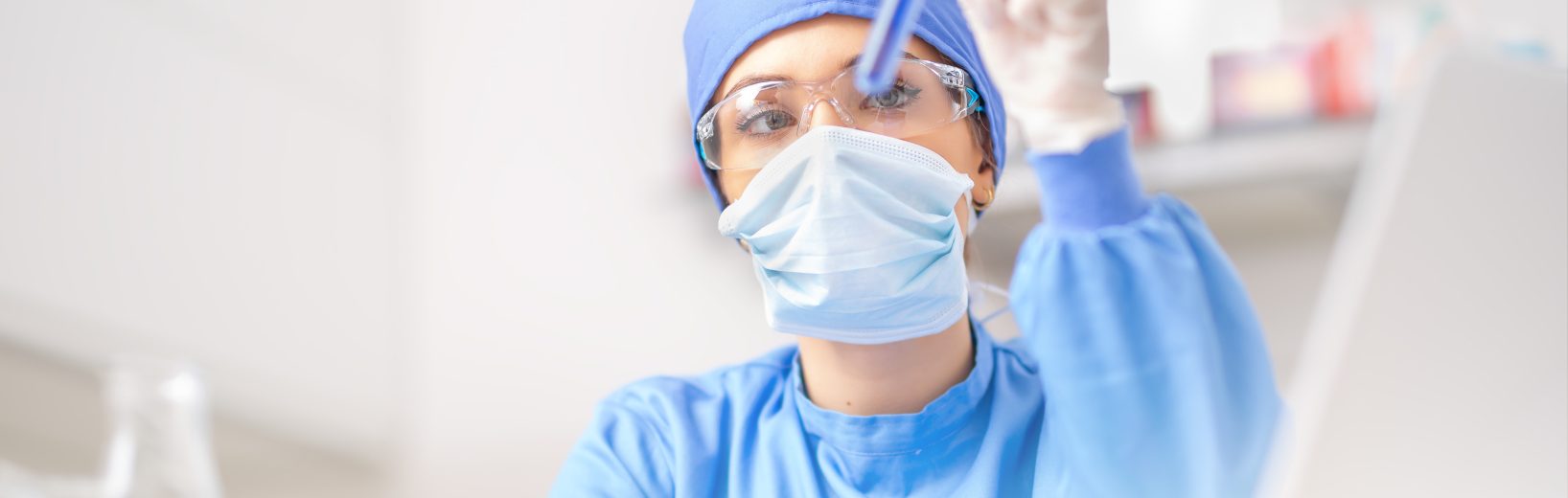 Gefährdungsbeurteilung im Labor sicher durchführen Frau betrachtet eingehend einen chemischen Stoff in einem Reagenzglas.