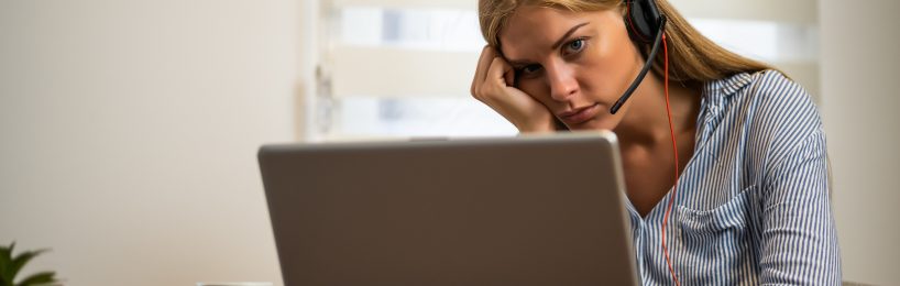 Zoom-Fatigue: Raus aus dem Hamsterrad! Frau sitzt müde und demotiviert vor dem Bildschirm - ein Anzeichen von Zoom Fatigue