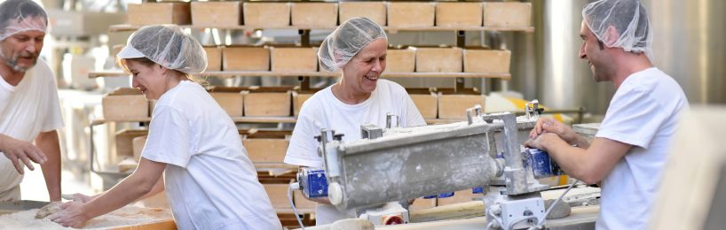 So sorgen Sie für gutes Klima in der Industriehalle Menschen, die in einer großen Indzustriehalle arbeiten