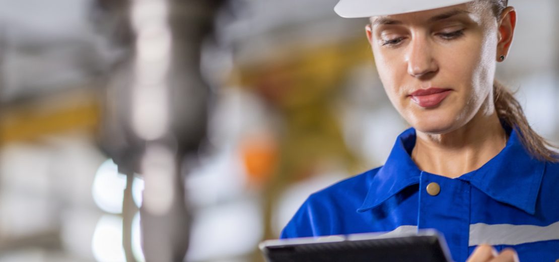 Eine Mitarbeiterin hackt auf Ihrer Checkliste einzelne Punkte im Rahmen der wiederkehrenden Prüfung für Arbeitsmittel ab.