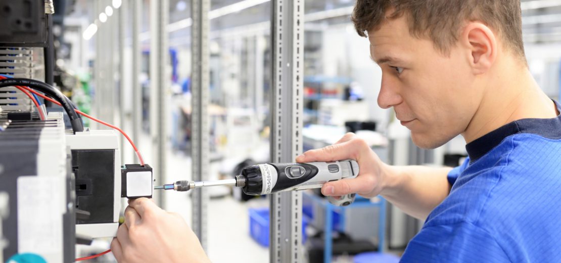 Junger Mann arbeitet an einer elektrischen Anlage