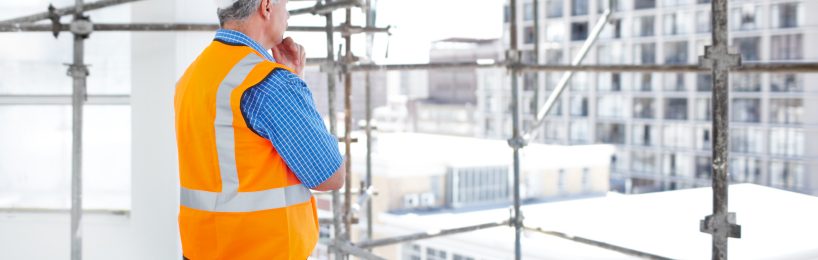 5 wichtige Regeln, die beim Arbeiten auf Gerüsten für Sicherheit sorgen Mann steht beim Arbeiten auf Gerüsten überlegt