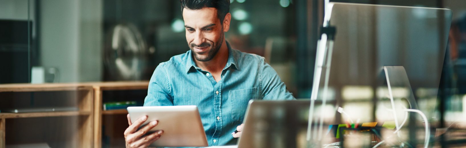 Sicherheitsfachkraft freut sich über etwas auf seinem Tablet; Symbolbild für Software Arbeitssicherheit.