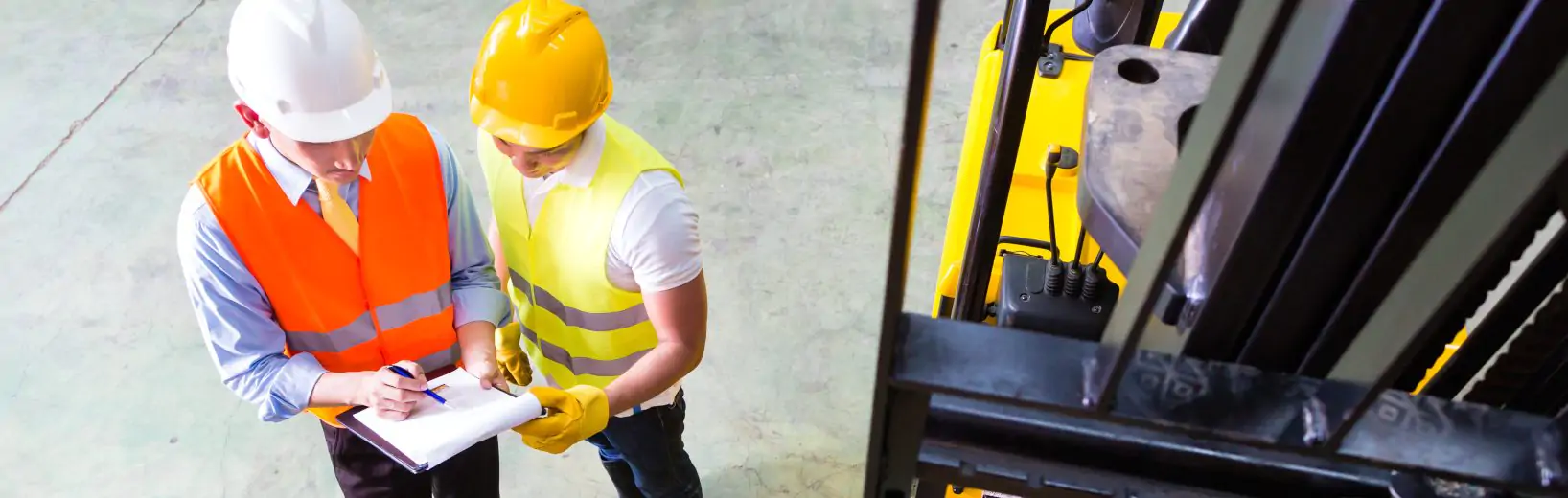 Zwei Arbeitsschützer mit einer Checkliste bei Begehungen im Arbeitsschutz.