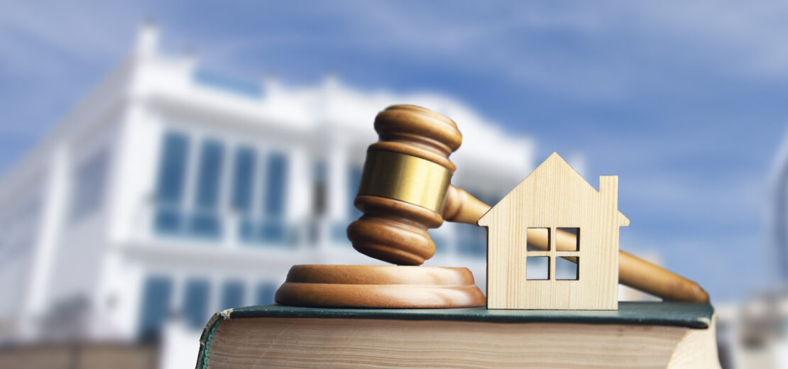 Gesetzbuch mit Modellhaus aus Holz und Gesetzeshammer aus dem Gericht beispielhaft für die Bauordnung aller Bundesländer
