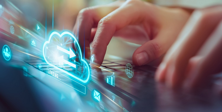 Eine Person sitzt am Rechner und schreibt auf der Tastatur, angezeigt wird ein Cloud-Symbol