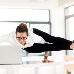 Frau macht Yoga am Bildschirmarbeitsplatz