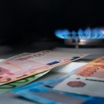 Geld im Vordergrund, Gasflamme im Hintergrund: Symbol für Energiesparen im Unternehmen