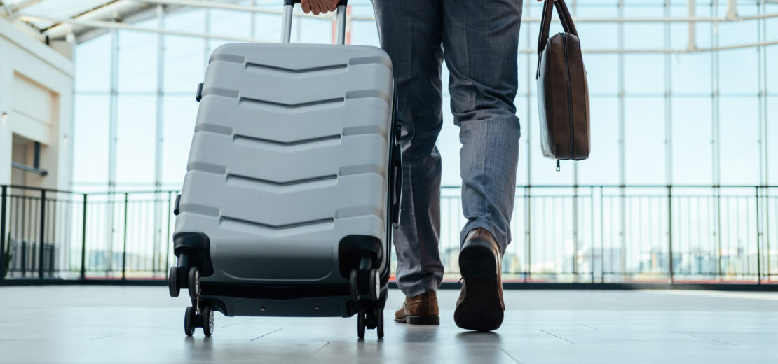 Mann mit Koffer am Flughafen