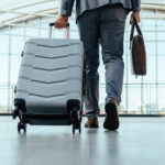 Mann mit Koffer am Flughafen