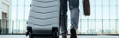 Mann mit Koffer am Flughafen