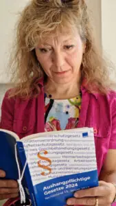 Frau liest in den aushangpflichtigen Gesetzen von Weka