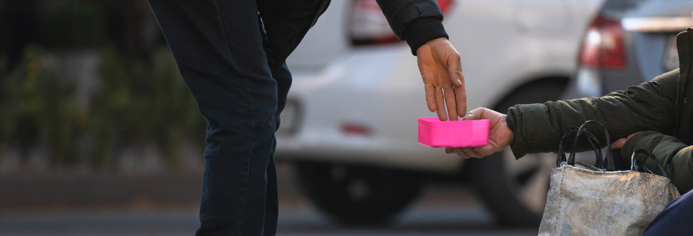 Mann gibt Obdachlosen eine Spende