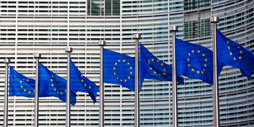 Mehr kommunale Mitbestimmung für Europa Europafahnen wehen im Wind vor einem Gebäude