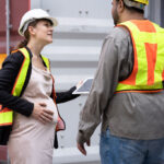 Schwangere Frau in der Arbeit im Gespräch. Symbolbild sozialer Arbeitsschutz.