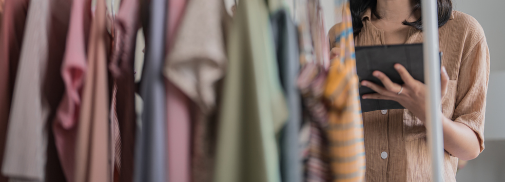 Auszubildende kontrolliert Waren in Kleiderladen