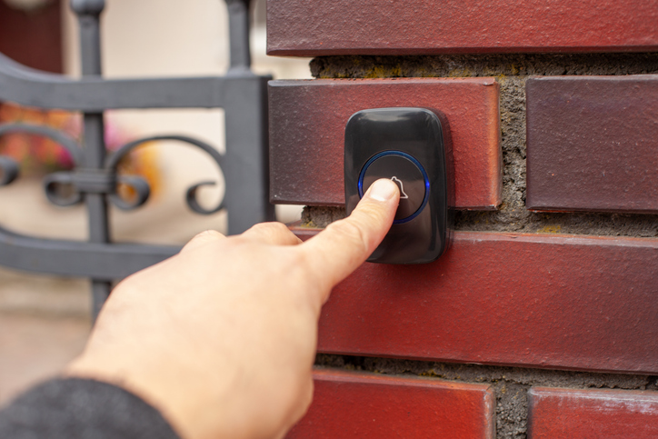 Zeigefinger drückt auf Türklingel