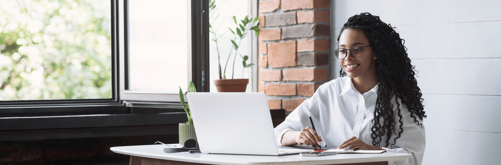 Erwerbsbeteiligung der Generation Z klettert auf Höchststand Sehr junge Frau bei der Arbeit vor Laptop