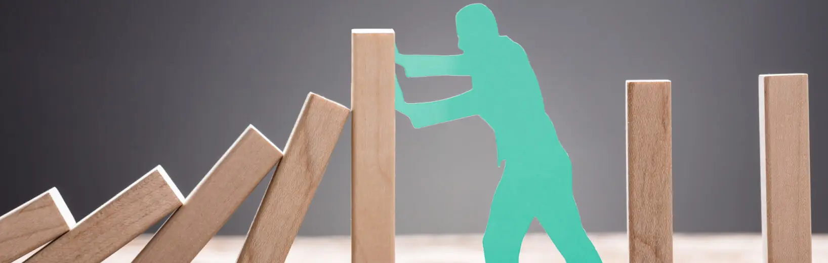 Mann blockiert Domino-Effekt