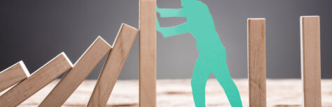 Mann blockiert Domino-Effekt