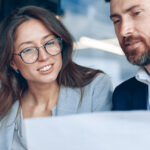 Frau und Mann im Büro bei der Arbeit vor dem Computer