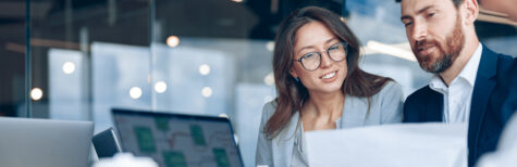 Frau und Mann im Büro bei der Arbeit vor dem Computer