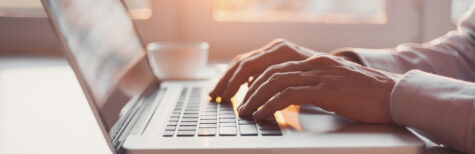 Person tippt auf Notebook-Tastatur