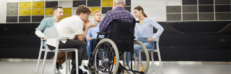 Mann im Rollstuhl sitzt mit anderen Personen im Stuhlkreis
