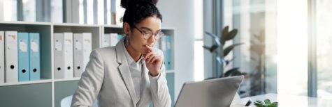 Junge Frau arbeitet an Laptop und denkt nach