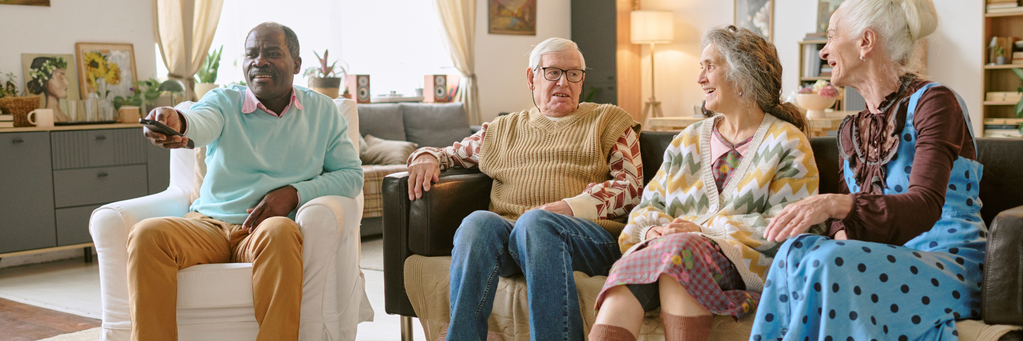 4 Rentner sitzen im Wohnzimmer