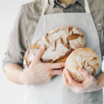 Bäcker hält Brote im Arm