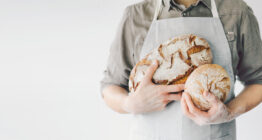 Bäcker hält Brote im Arm