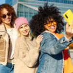 drei glückliche junge Frauen, die in der Stadt ein Selfie machen