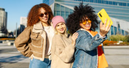 drei glückliche junge Frauen, die in der Stadt ein Selfie machen