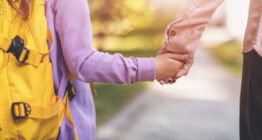 Schulkind hält Hand der Mutter, Nahaufnahme